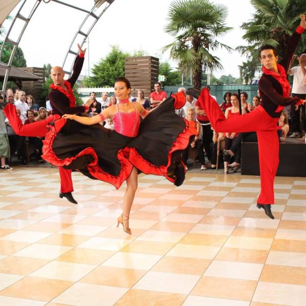 Due ballerine con abito rosso e nero in volteggio durante un esibizione all aperto