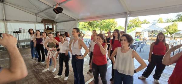 Un gruppo di allieve in posa prima di una esibizione, maglie rosse e bianche