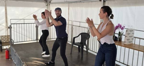 Una coppia che balla salsa durante un evento, con altre persone intorno